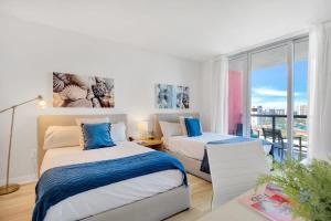 a hotel room with two beds and a balcony at Spectacular View with Balcony, Pool, Near Beach in Hallandale Beach +29 photos