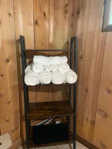 un estante lleno de toallas blancas en una habitación en John Wayne Cedar Oasis, en Cookstown