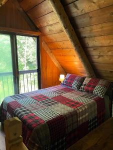 a bedroom with a bed in a wooden cabin at John Wayne Cedar Oasis in Cookstown