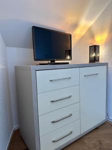uma cómoda branca com uma televisão por cima em WELCOME HOTEL - Hellbühl em Hellbühl