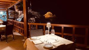 a table with two wine glasses on a balcony at UNA HOTELS Capotaormina in Taormina