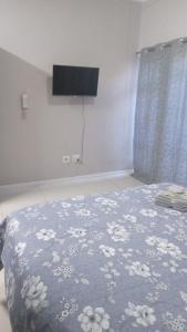 a bedroom with a bed with a blue blanket with flowers at Urban Studio Pvt Appartment in Durban
