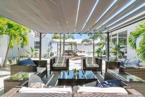 um pátio exterior com mesas e cadeiras de vime em Together but with Privacy 3 Units and Private Pool em Fort Lauderdale