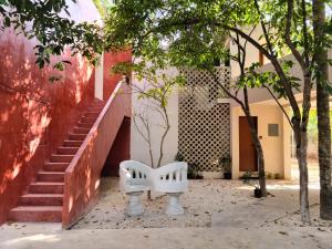 a white bench sitting next to a building with stairs at Apartments Mi Amado Chemby, Centro, Alberca, Wifi, Equipped, New, Gardens in Mérida