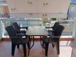 a table and chairs in a room with a balcony at Ligeia Bedrooms Nafplio in Nafplio