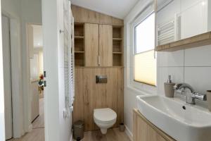a bathroom with a white toilet and a sink at Ostseecamp Ferienhaus "KleineDüne" in Scharbeutz +24 photos