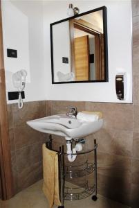 a white sink sitting under a mirror in a bathroom at La Filanda in Brescia