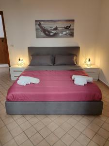 1 dormitorio con 1 cama grande y 2 toallas. en Le Case del Cortile, en Catania