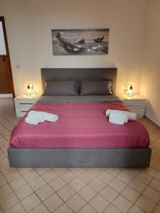 a bedroom with a large bed with two towels on it at Le Case del Cortile in Catania