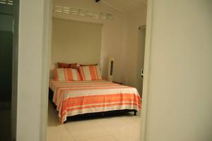 a bedroom with a bed with orange and white sheets at Finca Turistica Moniyamena, Encuentro con la Naturaleza in Villavicencio
