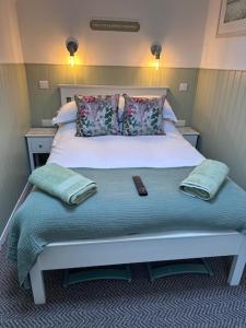 a bedroom with a bed with a remote control on it at The Little Garden Hideaway with Stunning Sea Views and Garden in Holyhead
