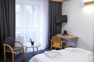 クリニツァ・ズドルイにあるWysoka noclegi ze śniadaniemのベッド2台、テーブルと椅子が備わるホテルルームです。