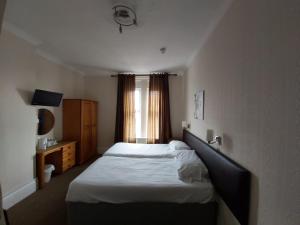a small bedroom with a bed and a window at Channel View Hotel in Sandown