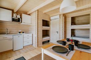 a kitchen with white cabinets and a wooden wall at Zam-zam apartman in Zamárdi