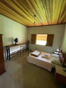 - une chambre avec un lit, une table et une fenêtre dans l'établissement Sítio Valle do Sol, à Rio das Flores