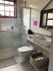 La salle de bains est pourvue de toilettes, d'un lavabo et d'une douche. dans l'établissement Sítio Valle do Sol, à Rio das Flores