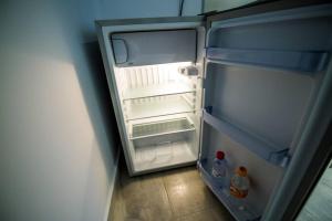 einem leeren Kühlschrank mit offener Tür in einem Zimmer in der Unterkunft 2 Bedrooms Apartment close to metro Dafni in Athens in Athen