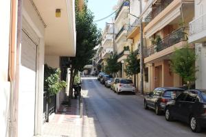 2 Bedrooms Apartment close to metro Dafni in Athens في أثينا: شارع فيه سيارات تقف على جانب الطريق