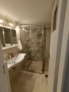 uma casa de banho com um chuveiro e um lavatório. em Your Athens home em Atenas