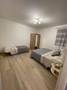 1 dormitorio con 2 camas y suelo de madera en La Valle Degli Ulivi, en Saludecio