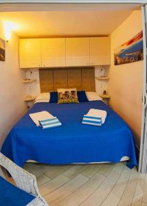ein Schlafzimmer mit einem blauen Bett und Handtüchern darauf in der Unterkunft Apparthenope in Neapel