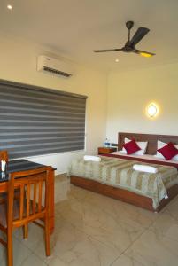 a bedroom with two beds and a ceiling fan at Coconut Palms Village Homestay in Kumarakom