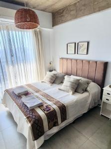 a bedroom with a large bed with a large window at Lavalle 12 - Bon Repos in San Miguel de Tucumán