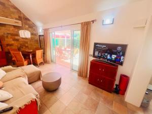 a living room with a couch and a flat screen tv at Espacioso Bungalow en Maspalomas in Maspalomas