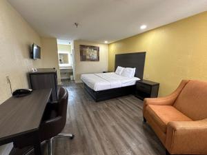 a hotel room with a bed and a desk at Rodeway Inn and Suites Hwy 290 in Houston