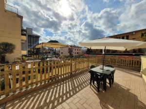 特雷維那諾羅馬諾的住宿－Alele Alloggio turistico，阳台的天井配有2张桌子和遮阳伞