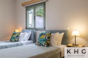 two beds with pillows in a room with a window at Hermes luxury apartment in Vlachata village! in Vlachata