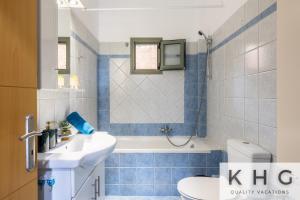 a bathroom with a sink and a tub and a toilet at Hermes luxury apartment in Vlachata village! in Vlachata