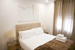 a bedroom with a white bed with towels on it at For You Rentals Espléndido Apartamento de tres Dormitorios BEI41 in Madrid