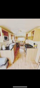 a large kitchen with wooden floors and a stove top oven at Static Caravan Marine Holiday Park in Rhyl