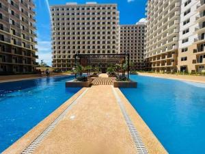 a large swimming pool in a city with tall buildings at At LBS 888 Condo Unit Rental-Full Relaxing Seaview 304-10Flr in Lapu Lapu City