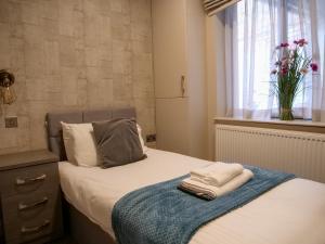 um quarto com uma cama com um vaso de flores em Luxe 2 Bed Apt - City Centre - Office - SmartTVs em Birmingham