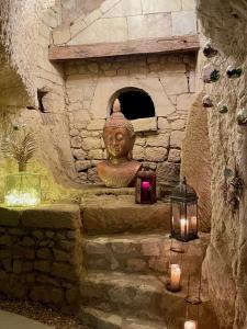 a statue in a stone wall with candles and a lantern at Château de Candes - Art & Spa in Candes-Saint-Martin