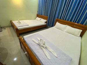 - une chambre avec 2 lits et des serviettes blanches dans l'établissement Hotel Bình An, à Vung Tau
