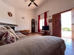 ein Wohnzimmer mit einem Bett und einem TV in der Unterkunft Cd-1383 Three Bedroom Villa With Pool in Viñuela