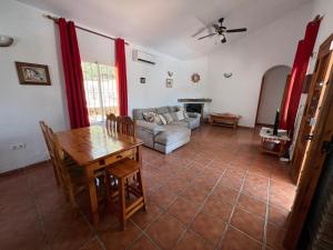 ein Wohnzimmer mit einem Tisch und einem Sofa in der Unterkunft Cd-1383 Three Bedroom Villa With Pool in Viñuela