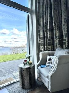 sala de estar con silla, mesa y ventana en Loch View at Lomond Castle en Balloch