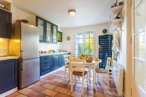 cocina con armarios azules, mesa y sillas en MAS DE GAIRAUT VI4395 By Riviera Holiday Homes en Niza