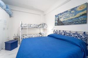 a bedroom with a blue bed and a painting on the wall at Affittacamere Cecilia in Castellammare del Golfo