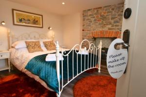a bedroom with a bed and a stone fireplace at Carew Inn in Tenby