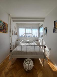 a white bed in a room with a window at Happy Place in Niš