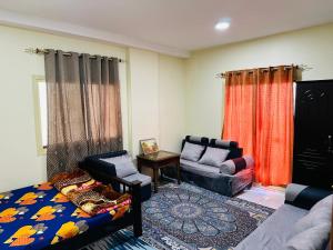 - un salon avec un canapé, une chaise et une table dans l'établissement City view furnished room, à Ajman