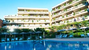 a hotel with chairs and umbrellas next to a swimming pool at Home Away Livorno - Suite Livorno Holiday Home Group in Livorno