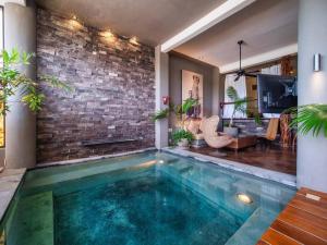 a swimming pool in a room with a brick wall at Casa Volare - Contemporary Oceanfront Villa in Santa Cruz Huatulco