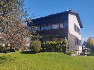 a house with a tree in front of it at CROWN LIVING Design Apartment - 2 Schlafzimmer - Küche - gratis Parkplatz - Abstellraum für Fahrräder/Ski in Mäder