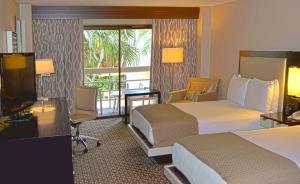 a hotel room with two beds and a television at DoubleTree by Hilton Hotel Houston Hobby Airport in Houston